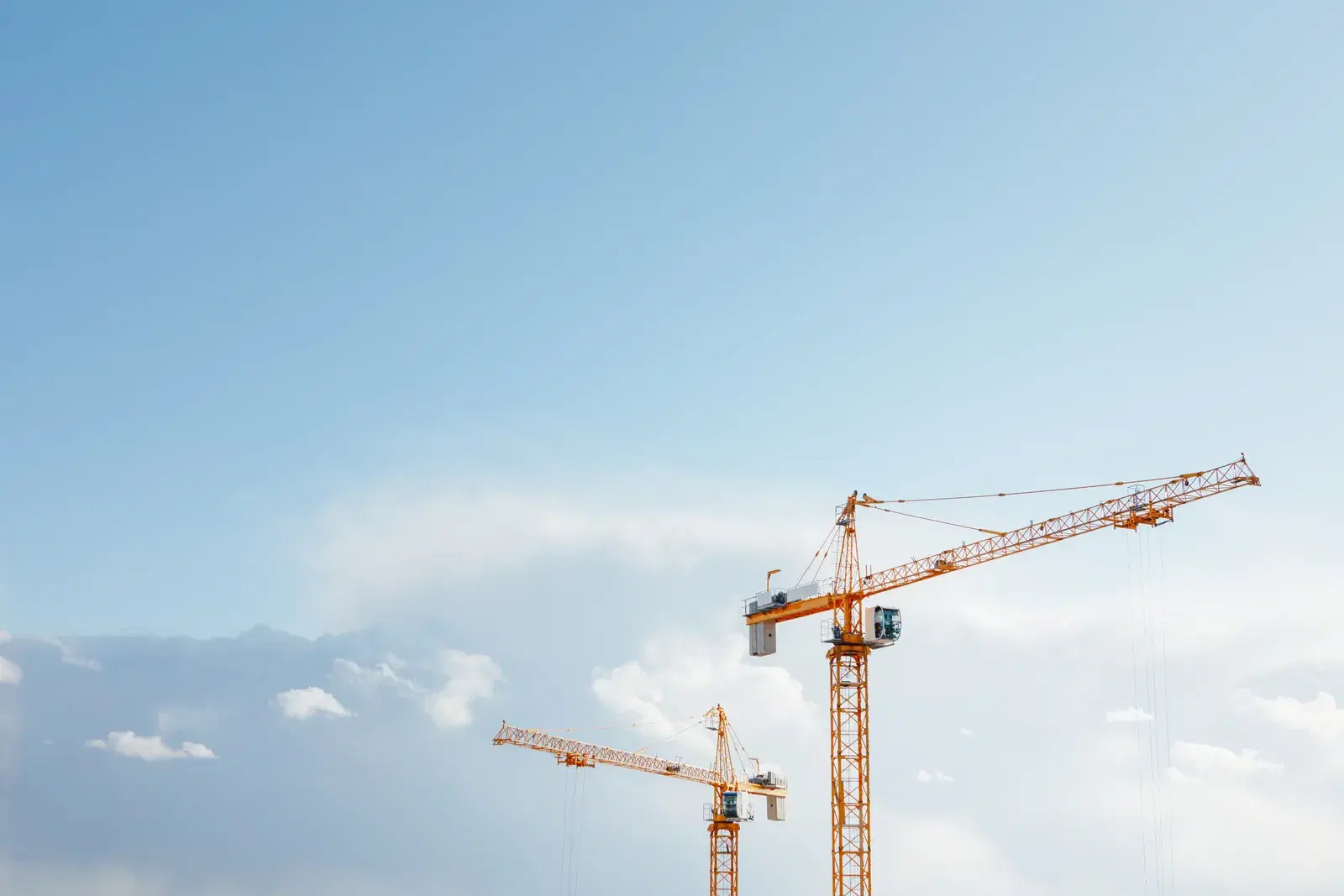 Tower cranes against a clear sky on a high-rise construction site